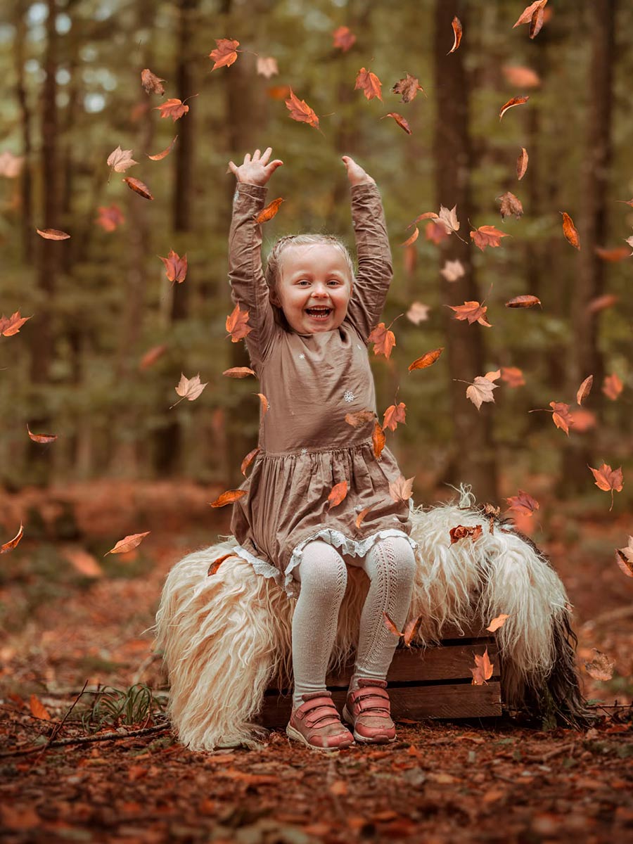 Sjov og naturlig børnefotografering af en pige i leg under det gyldne efterår i Randers. Autentiske minder fanget af en familiefotograf i Østjylland.