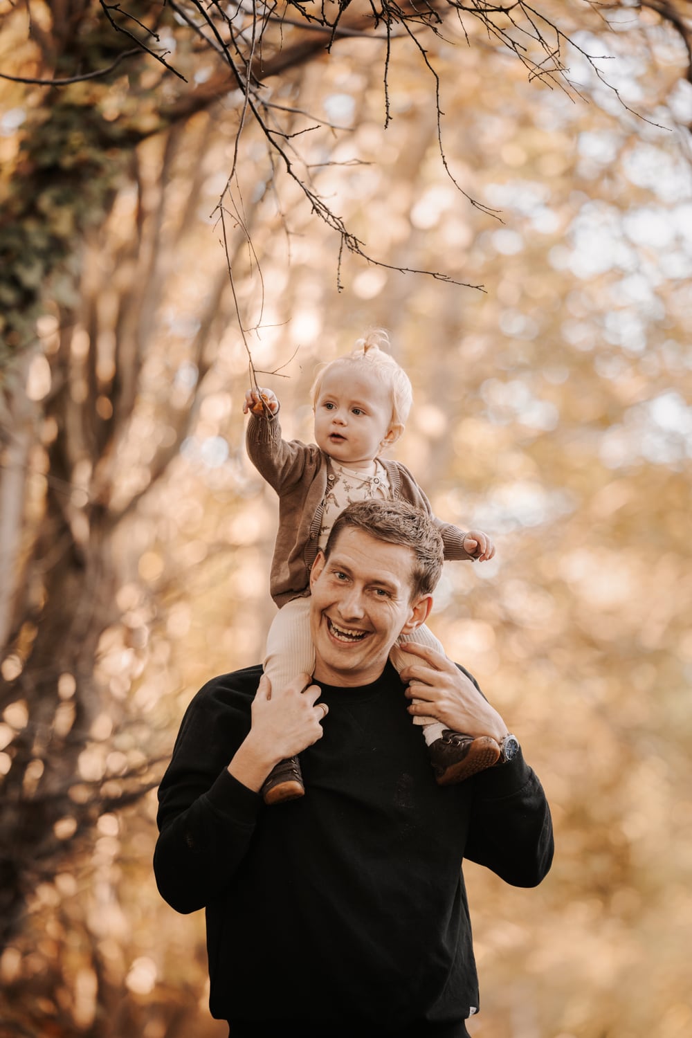 Far med sit barn på skuldrene i efterårsskoven – familiefotograf Randers